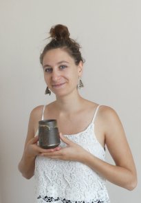 Clara Lombard, céramiste, présentant une de ses tasses artisanale.